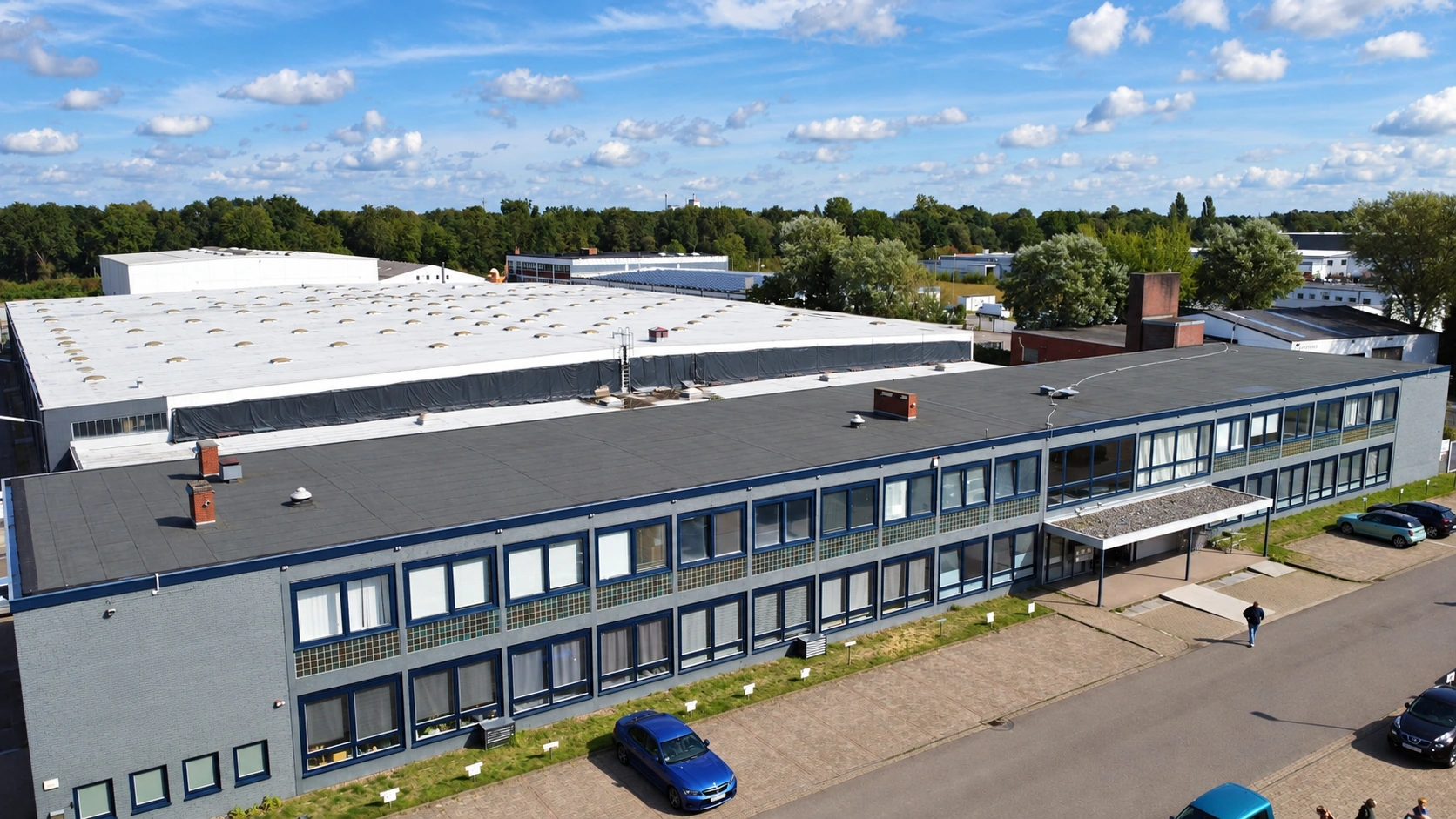 Aerial view of the building housing the Power Defence Group Bremen office, showing its blue-framed windows and entrance