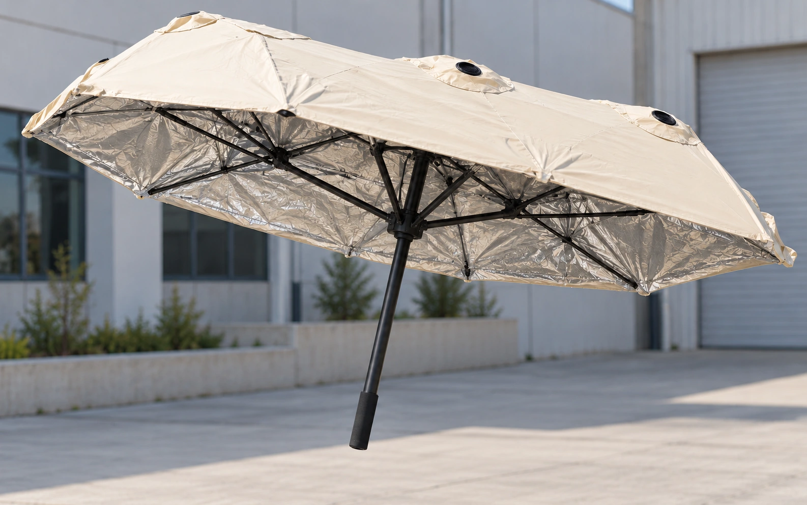 Portable beige Thermal Shield with reflective silver lining, folding black ribs and a slim black pole
